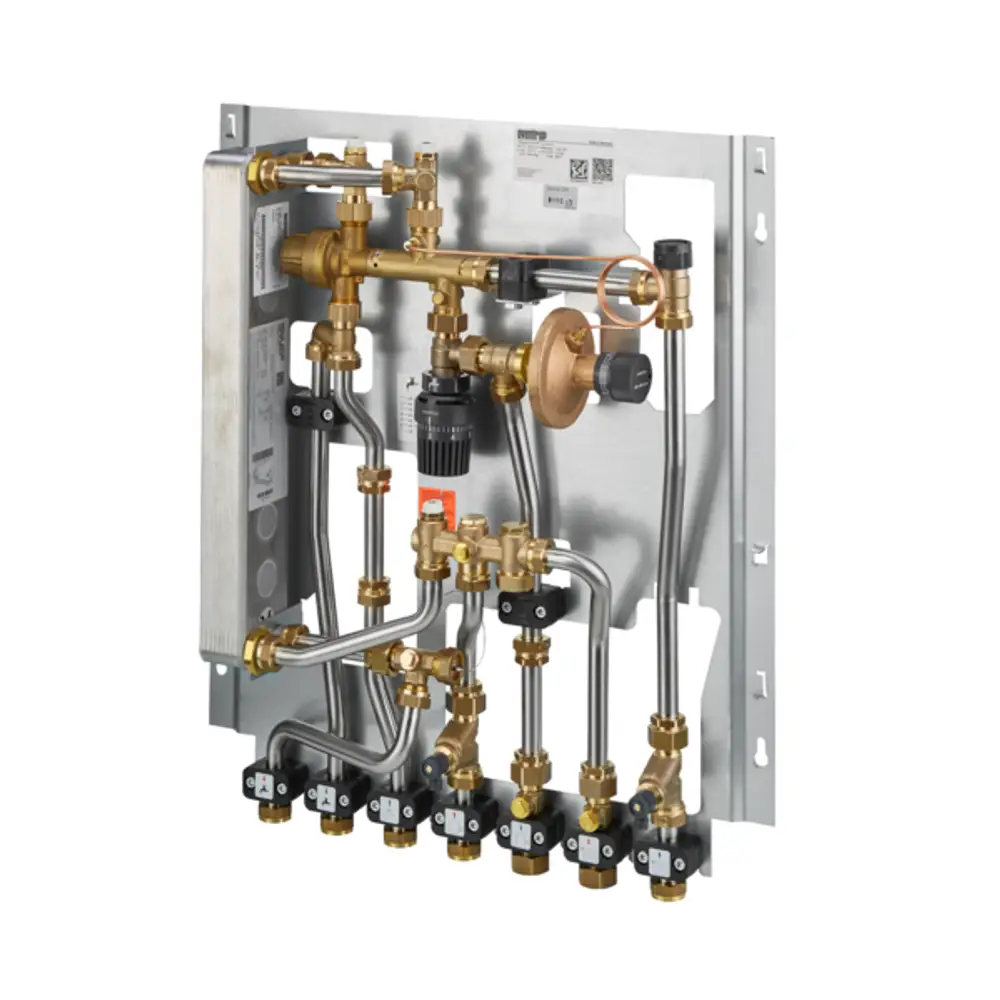 Oventrop Wohnungsstation mit mehreren Rohrleitungen und Ventilen zur Warmwasserbereitung, montiert auf einer Metallplatte, sowie einem Wärmeübertrager sichtbar.